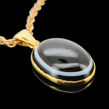 Load image into Gallery viewer, An oval banded agate pendant rubover set in yellow gold, with a yellow gold chain