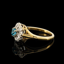 Load image into Gallery viewer, A blue zircon and diamond flower cluster ring in yellow and white gold, on a black background