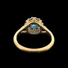 Load image into Gallery viewer, A blue zircon and diamond flower cluster ring in yellow and white gold, on a black background
