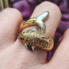 Load image into Gallery viewer, A yellow and white gold dolphin ring with diamonds and ruby eyes, modelled on a hand