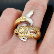 Load image into Gallery viewer, A yellow and white gold dolphin ring with diamonds and ruby eyes, modelled on a hand