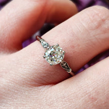 Load image into Gallery viewer, A diamond solitaire ring in platinum, modelled on a hand