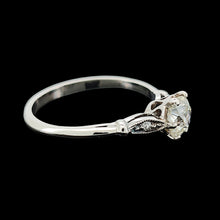 Load image into Gallery viewer, A diamond solitaire ring in platinum, on a black background