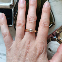 Load image into Gallery viewer, A single stone old cut diamond ring on a yellow gold band with white gold shoulder details, modelled on a hand