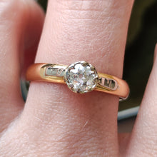 Load image into Gallery viewer, A single stone old cut diamond ring on a yellow gold band with white gold shoulder details, modelled on a hand