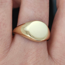 Load image into Gallery viewer, A yellow gold round signet ring, modelled on a hand