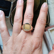 Load image into Gallery viewer, A yellow gold signet ring with a swivelling centre square, modelled on a hand