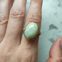 Load image into Gallery viewer, An oval, cabochon green agate dress ring in yellow gold, modelled on a hand