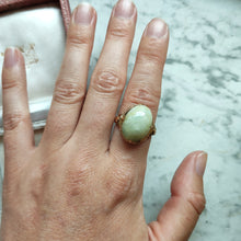 Load image into Gallery viewer, An oval, cabochon green agate dress ring in yellow gold, modelled on a hand