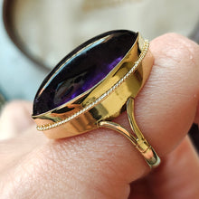 Load image into Gallery viewer, A yellow gold navette shaped cabochon cut amethyst solitaire ring, modelled on a hand