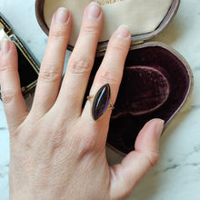 Load image into Gallery viewer, A yellow gold navette shaped cabochon cut amethyst solitaire ring, modelled on a hand