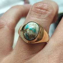 Load image into Gallery viewer, A yellow gold oval turquoise solitaire ring, modelled on a hand