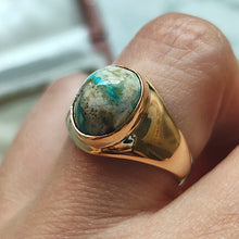 Load image into Gallery viewer, A yellow gold oval turquoise solitaire ring, modelled on a hand