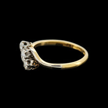 Load image into Gallery viewer, A three stone diamond trilogy ring in yellow gold and platinum, on a black background