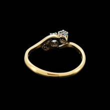 Load image into Gallery viewer, A three stone diamond trilogy ring in yellow gold and platinum, on a black background