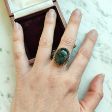 Load image into Gallery viewer, An oval moss agate ring in yellow gold, modelled on a hand