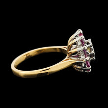 Load image into Gallery viewer, A circular ruby and diamond cluster ring in yellow and white gold, on a black background