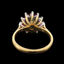 Load image into Gallery viewer, A circular ruby and diamond cluster ring in yellow and white gold, on a black background