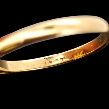 Load image into Gallery viewer, A close-up of a faded 18CT stamp inside a yellow gold ring shank, on a black background