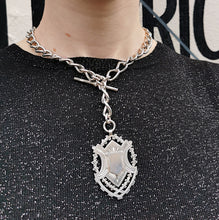 Load image into Gallery viewer, A silver Albert watch chain with large oval links, two lobster clasps, a T-bar and a shield shaped fob medal, modelled by a woman
