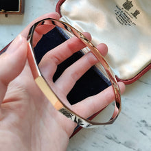 Load image into Gallery viewer, A rose gold solid slave bangle bracelet, held in a hand
