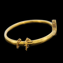 Load image into Gallery viewer, A yellow gold horseshoe bangle bracelet with rubies and diamonds, on a black background
