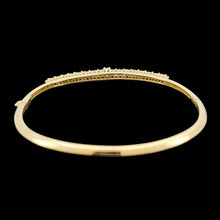 Load image into Gallery viewer, A yellow gold diamond bangle bracelet, on a black background
