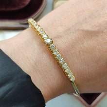 Load image into Gallery viewer, A yellow gold diamond bangle bracelet, modelled on a wrist
