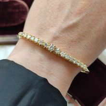 Load image into Gallery viewer, A yellow gold diamond bangle bracelet, modelled on a wrist
