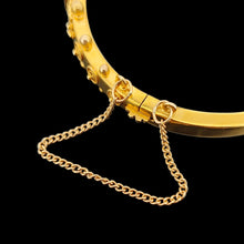 Load image into Gallery viewer, A yellow gold Etruscan style bangle bracelet set with emeralds and diamonds, with a safety chain
