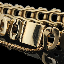 Load image into Gallery viewer, A close-up of a yellow gold bracelet clasp and safety chain, on a black background
