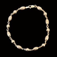 Load image into Gallery viewer, Gold beaded bracelet on a black background
