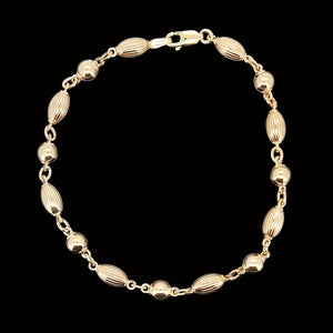 Gold beaded bracelet on a black background