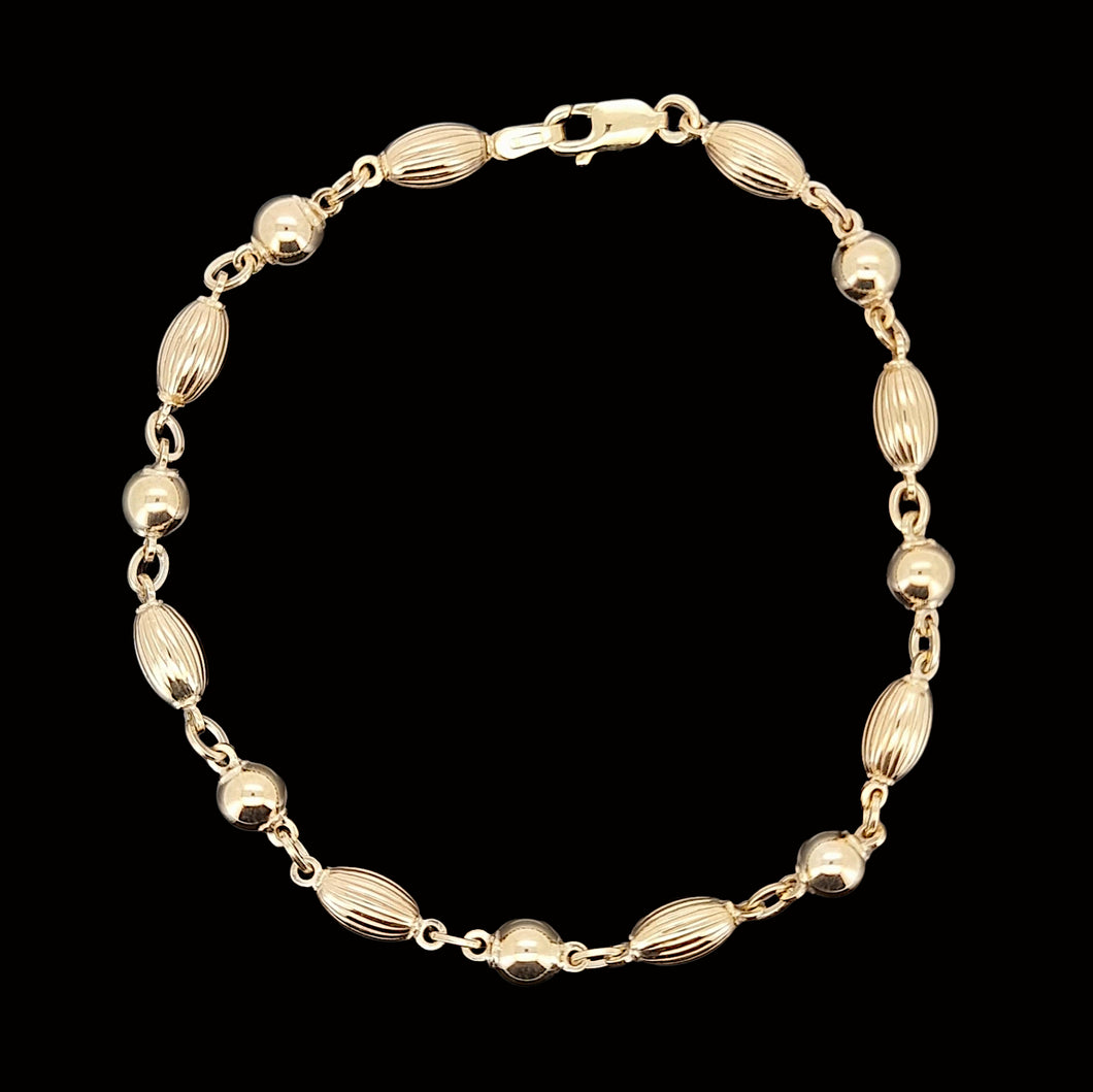 Gold beaded bracelet on a black background