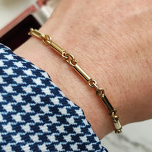 Load image into Gallery viewer, A yellow gold tube link bracelet modelled on a wrist
