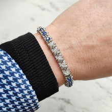 Load image into Gallery viewer, A sapphire and diamond white gold line bracelet, modelled on a wrist
