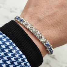 Load image into Gallery viewer, A sapphire and diamond white gold line bracelet, modelled on a wrist
