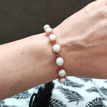 Load image into Gallery viewer, A pearl and ruby bracelet in rose gold, modelled on a wrist
