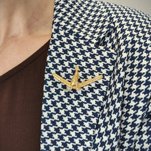 Load image into Gallery viewer, A boomerang shaped brooch with a kangaroo reading BEST WISHES, in yellow gold, modelled on the lapel of a houndstooth pattern jacket
