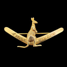 Load image into Gallery viewer, A boomerang shaped brooch with a kangaroo reading BEST WISHES, in yellow gold, on a black background
