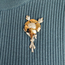 Load image into Gallery viewer, A two tone gold flower brooch with diamonds, modelled by a woman wearing a blue top
