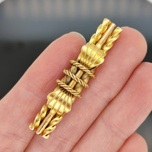 Load image into Gallery viewer, A yellow gold twist and rope design bar brooch, held in a hand
