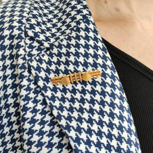 Load image into Gallery viewer, A yellow gold twist and rope design bar brooch, modelled on the lapel of a houndstooth print jacket
