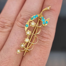 Load image into Gallery viewer, Gold brooch with turquoise and pearl stones held on a hand
