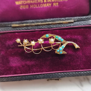 Gold brooch with pearls and turquoise stones on a purple velvet background