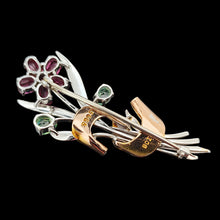 Load image into Gallery viewer, A ruby and green zircon flower bouquet brooch in white and rose gold, on a black background
