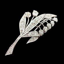 Load image into Gallery viewer, A white gold lily of the valley floral brooch set with diamonds, on a black background
