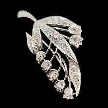 Load image into Gallery viewer, A white gold lily of the valley floral brooch set with diamonds, on a black background
