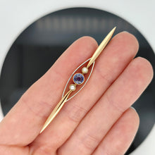 Load image into Gallery viewer, A yellow gold sapphire and pearl bar brooch, held in a hand
