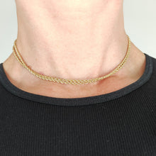 Load image into Gallery viewer, A yellow gold twisted rope chain with a bolt ring clasp, modelled by a woman wearing a black top
